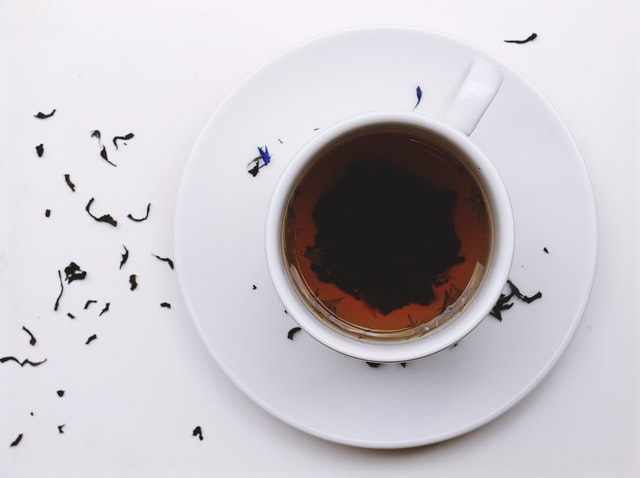 An image of a cup of tea with leaves floating in it.