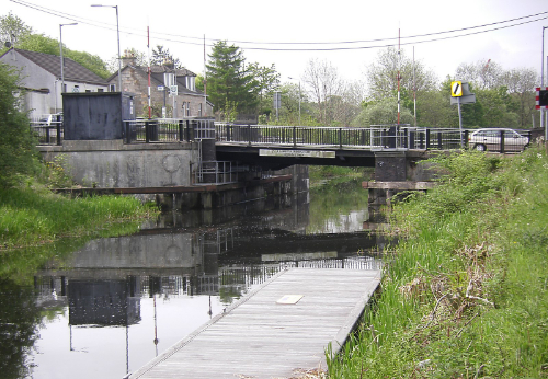 A bridge over a canal, with grass banks on either side.